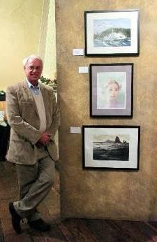 Jeff waters stands to the side of three of his prized watercolor works.